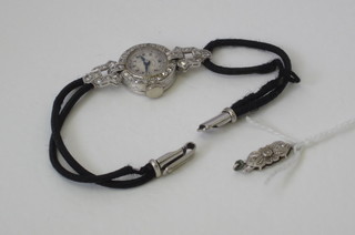 A lady's cocktail wristwatch by Kendal & Dent, contained in a platinum case set diamonds