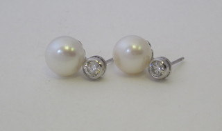 A pair of pearl and diamond ear studs, approx 0.60ct