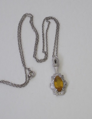 A white gold pendant hung an orange stone on a fine chain