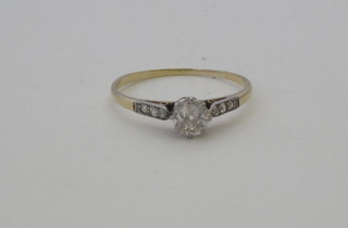 A gold dress ring set a solitaire diamond and with diamonds to  the shoulders