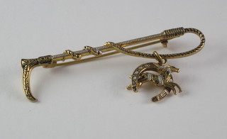 A gilt metal stock pin in the form of a riding crop