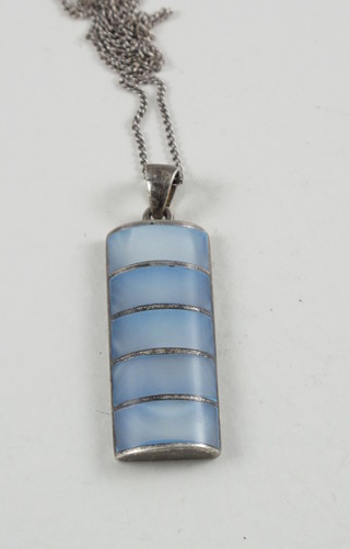 A fine silver chain hung a silver and enamelled pendant