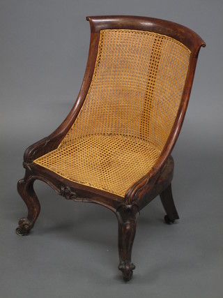 A Victorian rosewood tub back nursing chair with woven cane  seat and back, raised on cabriole supports