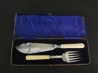 A pair of silver plated fish servers in a plush case