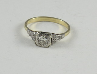 An 18ct yellow gold dress ring set a circular diamond and with 6  diamonds to the shoulders