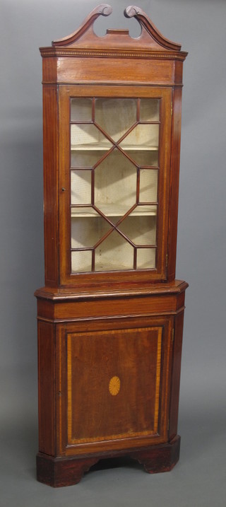 An Edwardian inlaid mahogany 2 tier corner cabinet, the upper section with with broken pediment, fitted shelves enclosed by  glazed panelled doors, the base fitted a cupboard enclosed by  panelled doors, raised on bracket feet 26"
