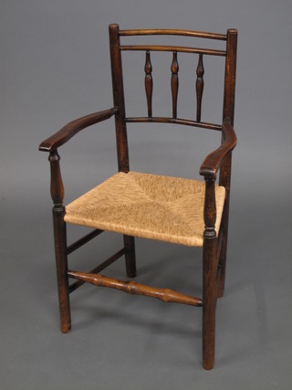 An elm stick and rail back open arm carver chair with woven  rush seat