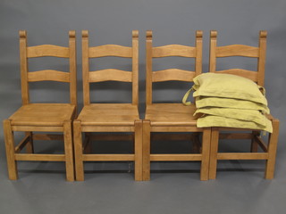 A set of 4 hardwood ladder back dining chairs with solid seats, raised on square tapering supports