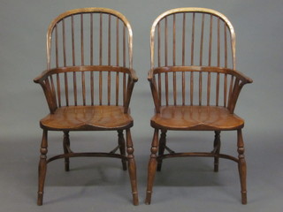 A set of 6 elm stick and rail back Windsor chairs with cow horn stretchers, raised on turned supports