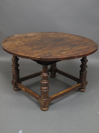 An 18th Century elm oval drop flap dining table, raised on  turned supports with box frame stretcher 50"