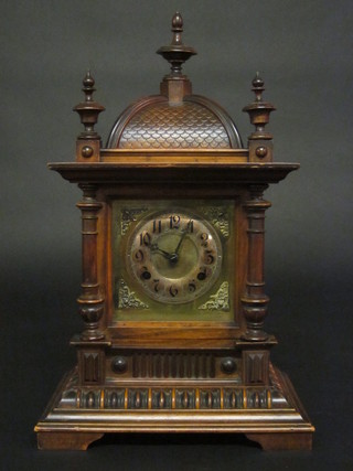 An Edwardian Continental bracket clock with gilt dial and  silvered chapter ring contained in a carved walnut case