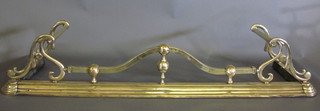 An Art Nouveau brass fire curb