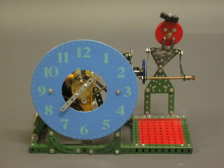 A red and green Meccano clock decorated a figure of a standing  man