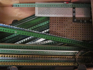 A collection of various lengths of green Meccano