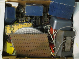 A box containing various Meccano motors etc