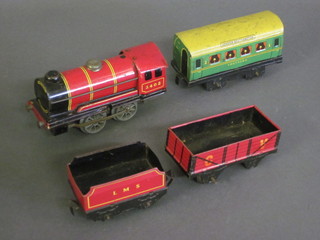 A clockwork locomotive together with a tender and an open  wagon