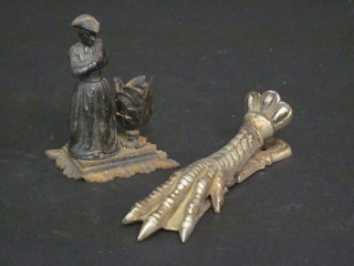 A French letter clip in the form of a claw marked JHP 5"  together with a spelter taper stick in the form of a standing cleric