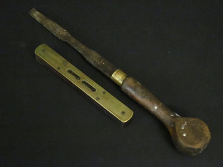 A brass and wooden bound spirit level and an old screwdriver