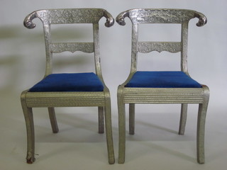 A set of 4 Adam style embossed "silver" covered bar back dining chairs, raised on sabre supports