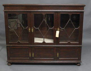 A 1930's oak display cabinet, fitted adjustable shelves enclosed  by astragal glazed panelled doors, the base fitted 3 cupboards  enclosed by panelled doors, raised on bracket feet 59"