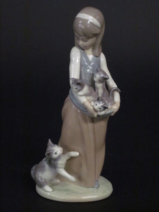 A Lladro figure of a standing girl with kittens 9 1/2"