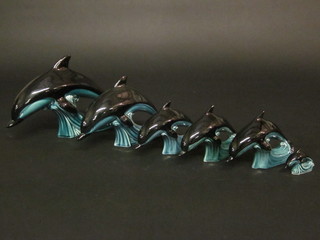 A set of 6 various graduated blue glazed Poole Pottery figures of dolphins