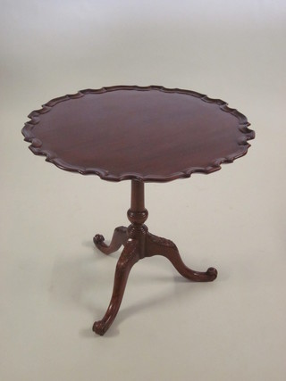 A Georgian style circular mahogany snap top wine table with pie crust edge, raised on pillar and tripod supports 30"