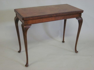 A 1930's Queen Anne style rectangular walnut card table with crossbanded top, raised on cabriole supports 36"