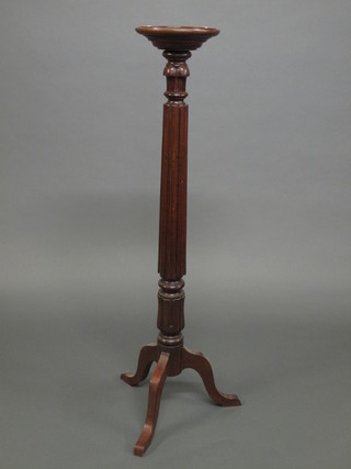 A Victorian turned mahogany torchere raised on pillar and tripod supports