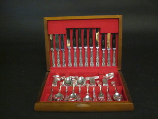 A canteen of queens pattern silver plated flatware contained in a walnut canteen box