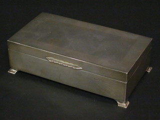 A rectangular silver cigarette box with hinged lid, raised on bracket feet, Birmingham 1959, 6 1/2"