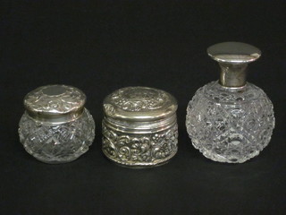 A circular cut glass globular shaped scent bottle with silver lid 3", a circular cut glass dressing table jar with silver lid, an  ointment jar contained in an embossed white metal case 2"