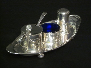 An Edwardian 3 piece silver condiment set of circular form comprising, salt, pepper and mustard pot, raised on a boat shaped  stand with bun feet, Chester 1909, 6 1/2 ozs