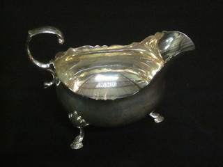 A Victorian silver sauce boat with wavy cut border and C scroll handle, raised on 3 hoof feet, London 1882, 4 1/2 ozs