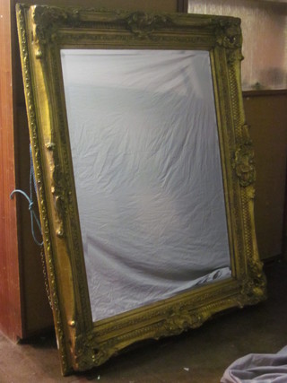 A large bevelled plate wall mirror contained in a decorative gilt  frame 63"