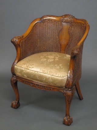A Queen Anne style walnut tub back double cane bergere chair, raised on cabriole supports