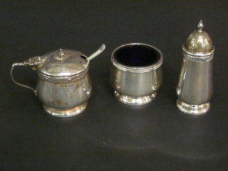 A silver 3 piece condiment set with salt, pepper and mustard pot complete with blue glass liners, Birmingham 1920
