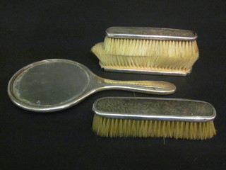 A 4 piece silver and tortoiseshell backed dressing table set comprising hand mirror and 3 clothes brushes, Birmingham 1945