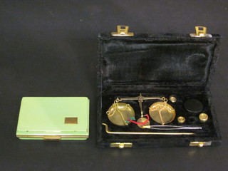 A green enamelled and gilt metal rectangular compact and a gold scales contained in a black plush case