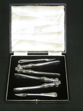 A pair of silver plated nut crackers and a pair of nut picks, cased