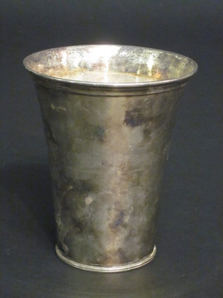 A waisted white metal beaker