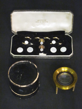 A table magnifying lens and a set of mother of pearl finished  dress studs