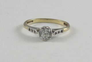A 9ct gold dress ring set a white stone and with white stones to the shoulders