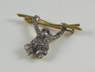 A bar brooch in the form of a monkey set rubies and diamonds