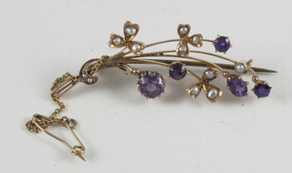 A gold floral spray bar brooch set amethysts and pearls