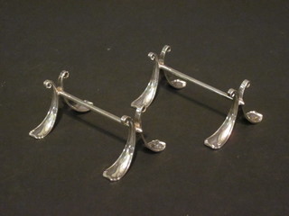 A pair of silver plated knife rests