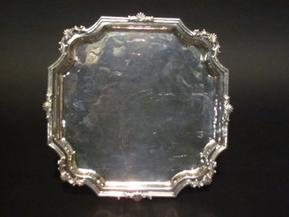 A square Georgian white metal salver with bracket border, raised on panel supports 11"  ILLUSTRATED