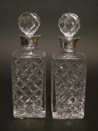 A pair of cut glass spirit decanters and stoppers with silver mounts