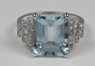A lady's 18ct white gold dress ring set a rectangular cut aquamarine and with numerous diamonds to the stepped  shoulders, approx 0.40.5.15ct