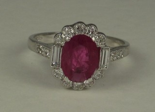A lady's 18ct white gold dress ring set an oval cut ruby  surrounded by numerous diamonds approx 0.50/1.70ct